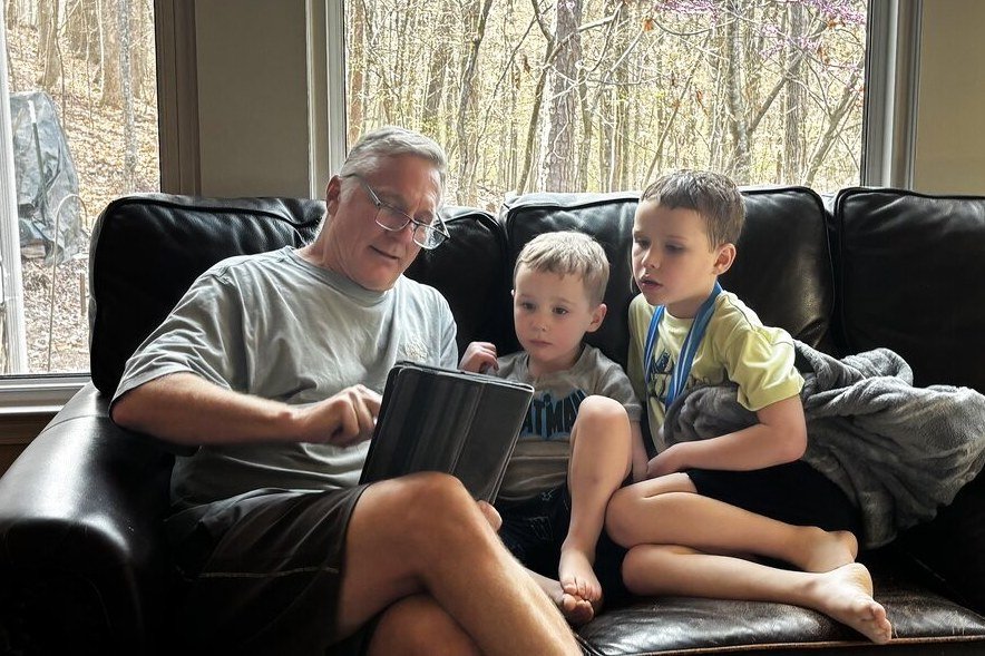 Todd reading on the sofa with his two great-nephews